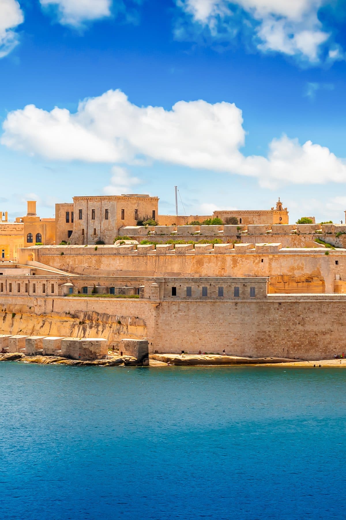 Fort St Angelo's honey-coloured bastions rising straight out of the Grand Harbour under a bright sky.